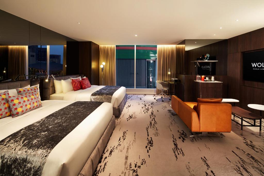 吉隆坡WOLO Kuala Lumpur的酒店客房配有两张床和一张书桌