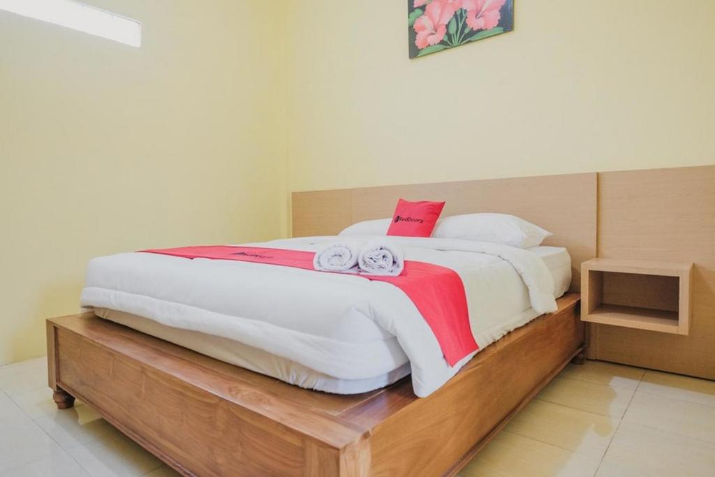 LampungRedDoorz near RS Imanuel Lampung的一间卧室配有一张床,上面有两条毛巾