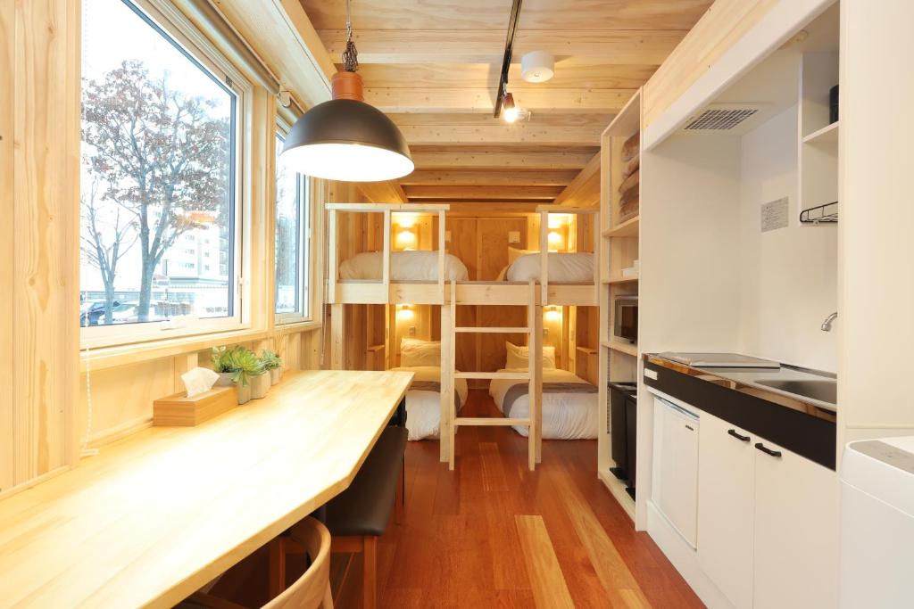 札幌JR Mobile Inn Sapporo kotoni的一间小厨房,位于一个小房子内,配有木桌