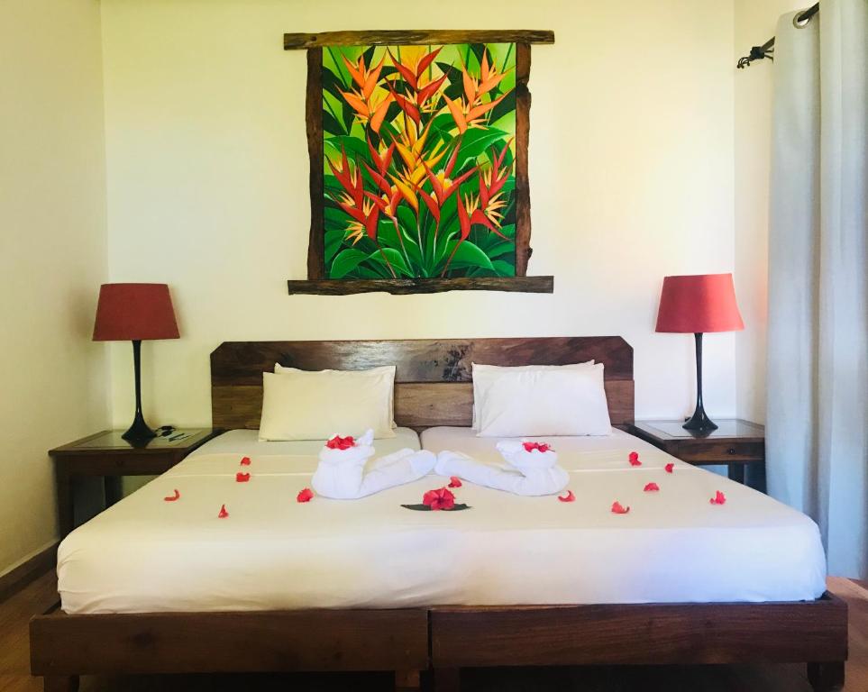 留尼汪Villa Des Flots的一间卧室配有带2条毛巾和鲜花的床