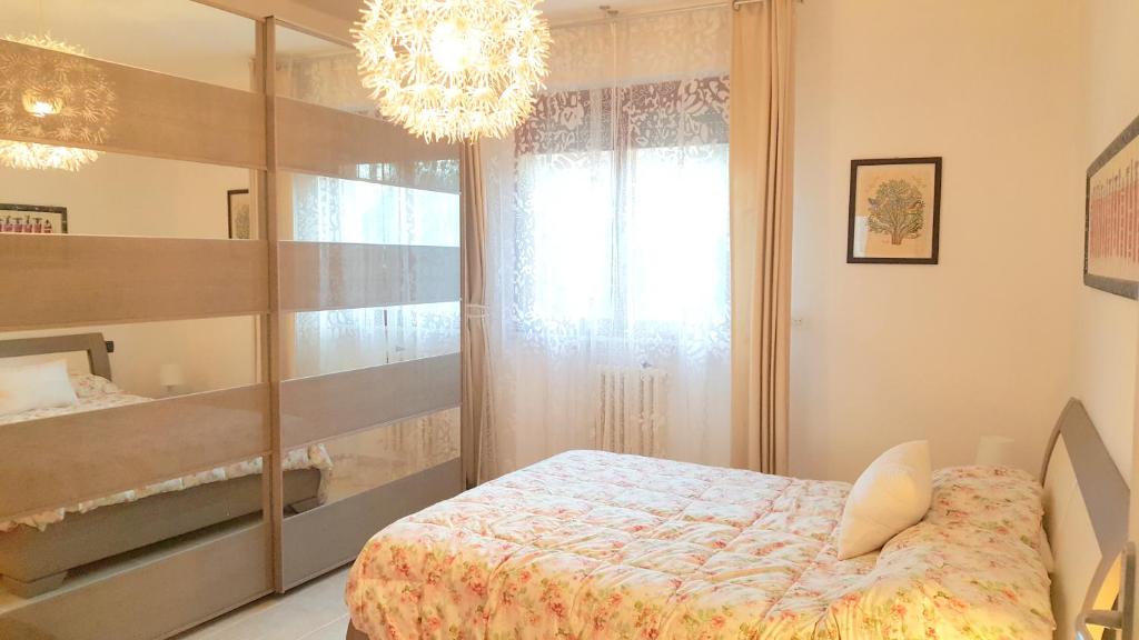 马里纳·迪·比萨Casa del Sole - Sunshine Home的一间卧室配有一张床和一个吊灯