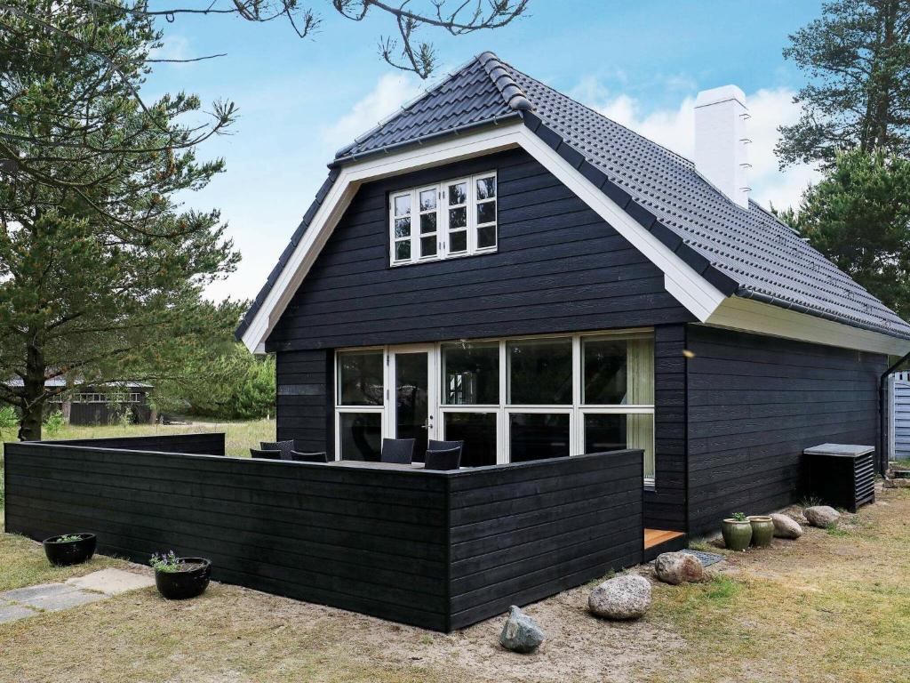 MosevråHoliday Home Grævlingevej II的一间设有许多窗户的黑色房子