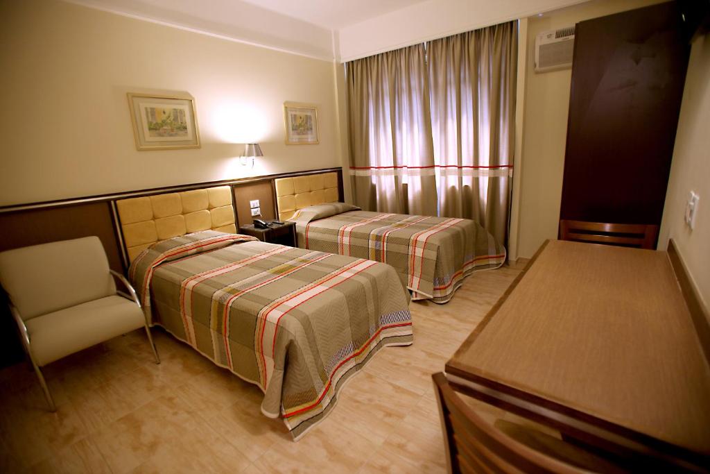 圣保罗索内卡广场酒店的酒店客房,配有两张床和椅子