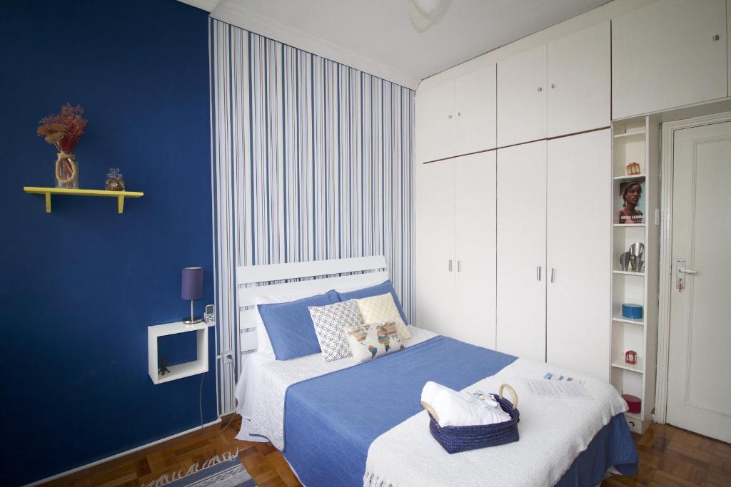 里约热内卢LGBT Friendly - Quarto em Ipanema Posto 9 - Casa de Vitor e Carlos的蓝色的卧室,配有一张蓝色墙壁的床
