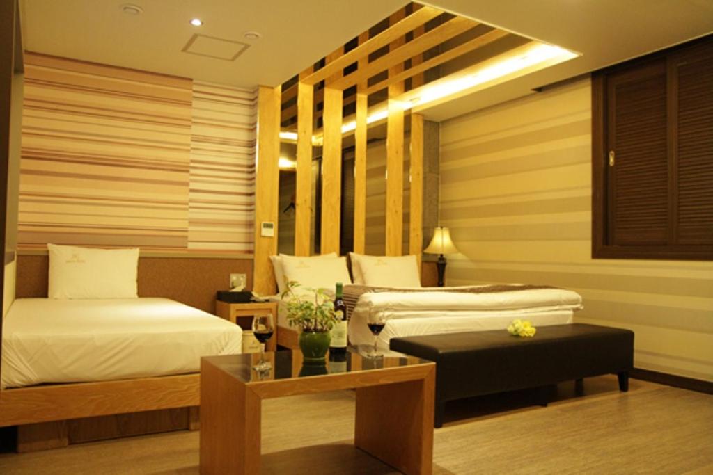 安东市高丽酒店的酒店客房设有两张床和一张桌子。