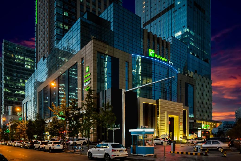 沈阳沈阳北站智选假日酒店的一条城市街道,汽车停在大楼前
