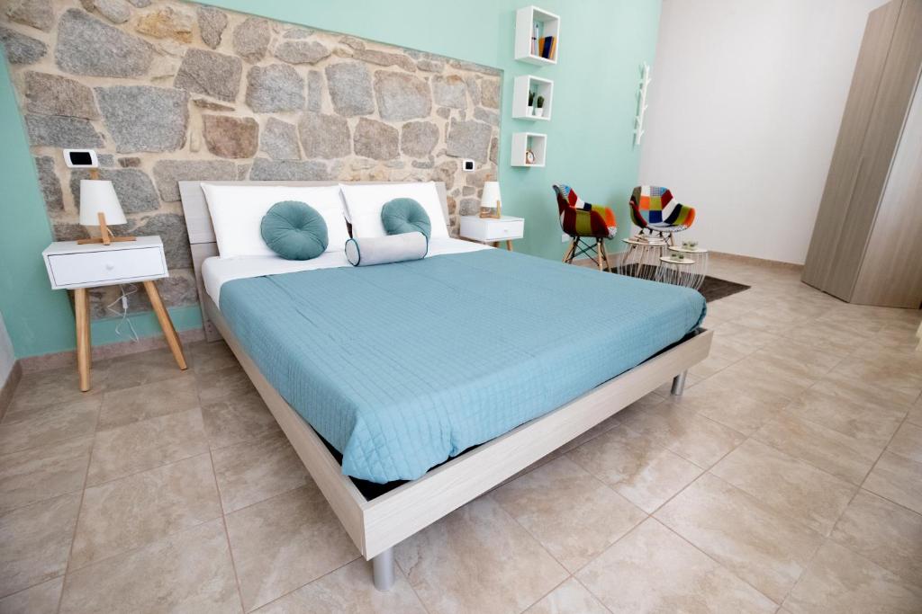 古斯皮尼B&B Vico 10的一间卧室设有一张床和石墙
