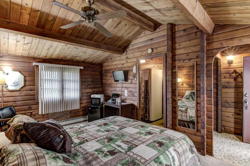 Rib LakeRib Waters Inn的一间卧室配有一张床和吊扇