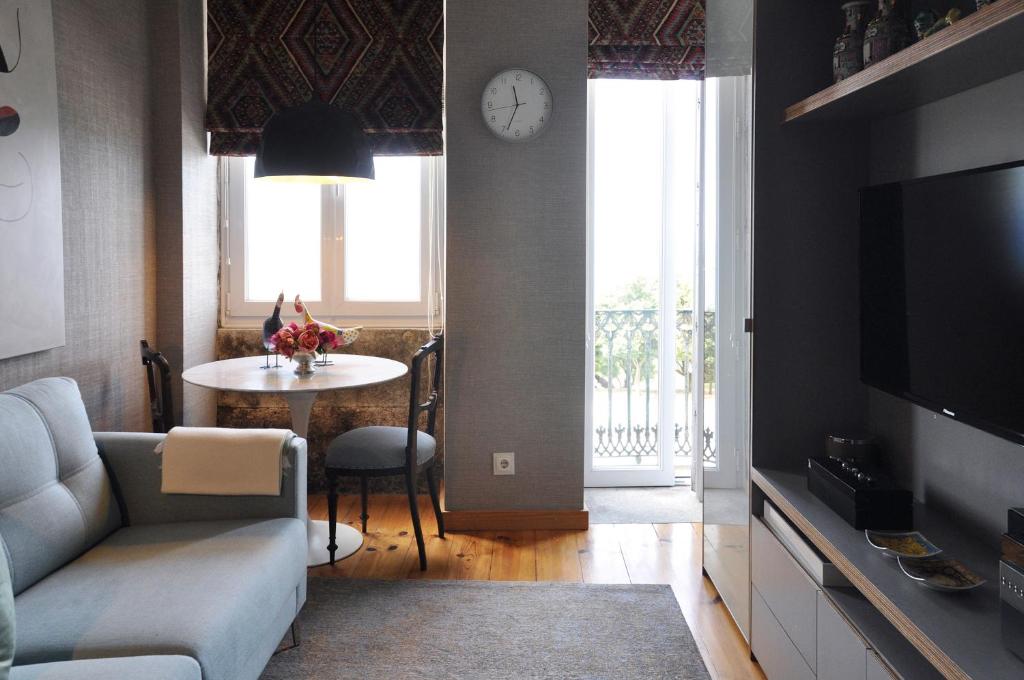波尔图Apartment by the Sea的客厅配有沙发和带时钟的桌子