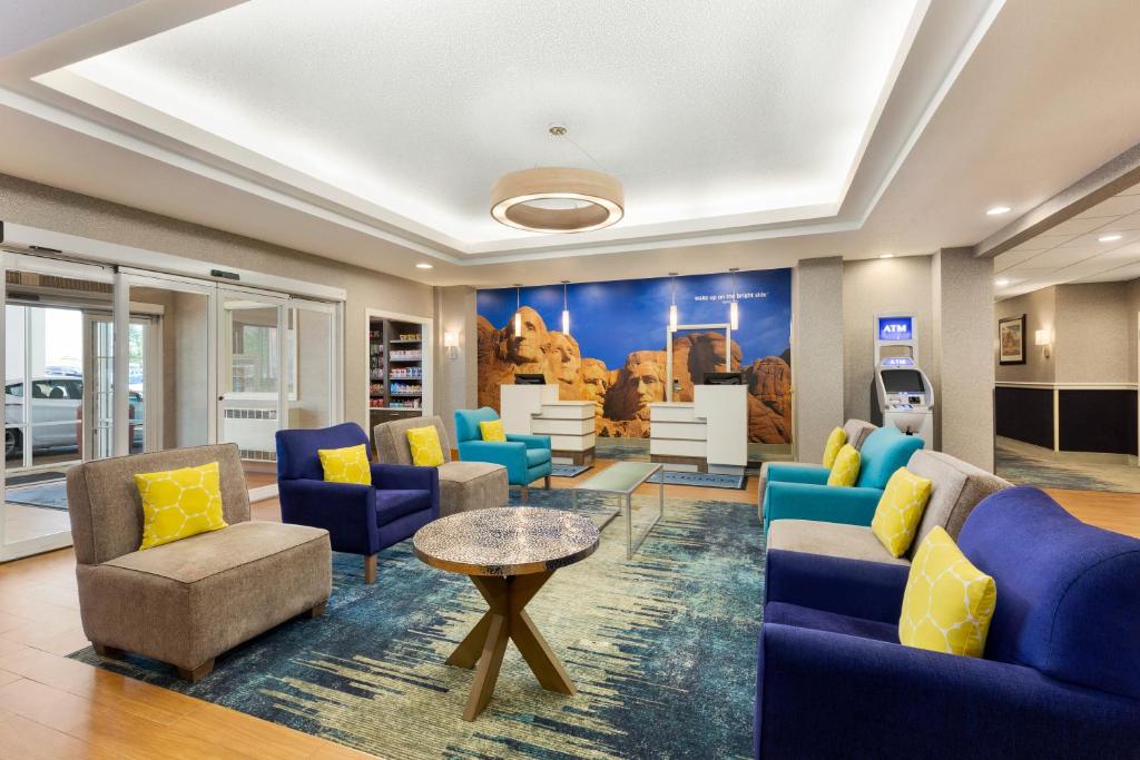 拉皮德城拉皮德城拉金塔旅馆及套房的一间设有蓝色椅子和桌子的等候室