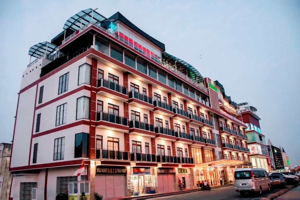 巴淡岛中心绿色玫瑰酒店的一条城市街道上的红色和白色大建筑