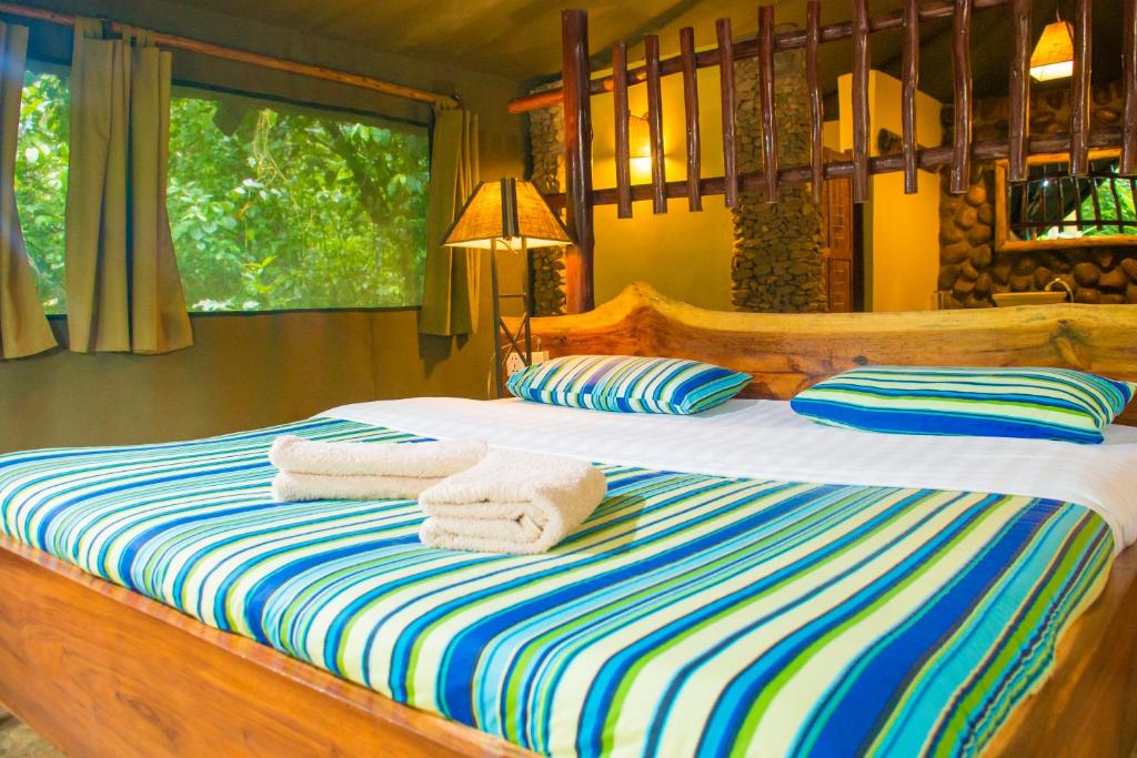 KyenjojoKibale Forest Camp by NATURE LODGES LTD的一间卧室配有带毛巾的床