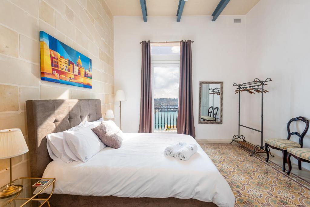 瓦莱塔Harbour Heights的卧室设有一张白色大床和一扇窗户。