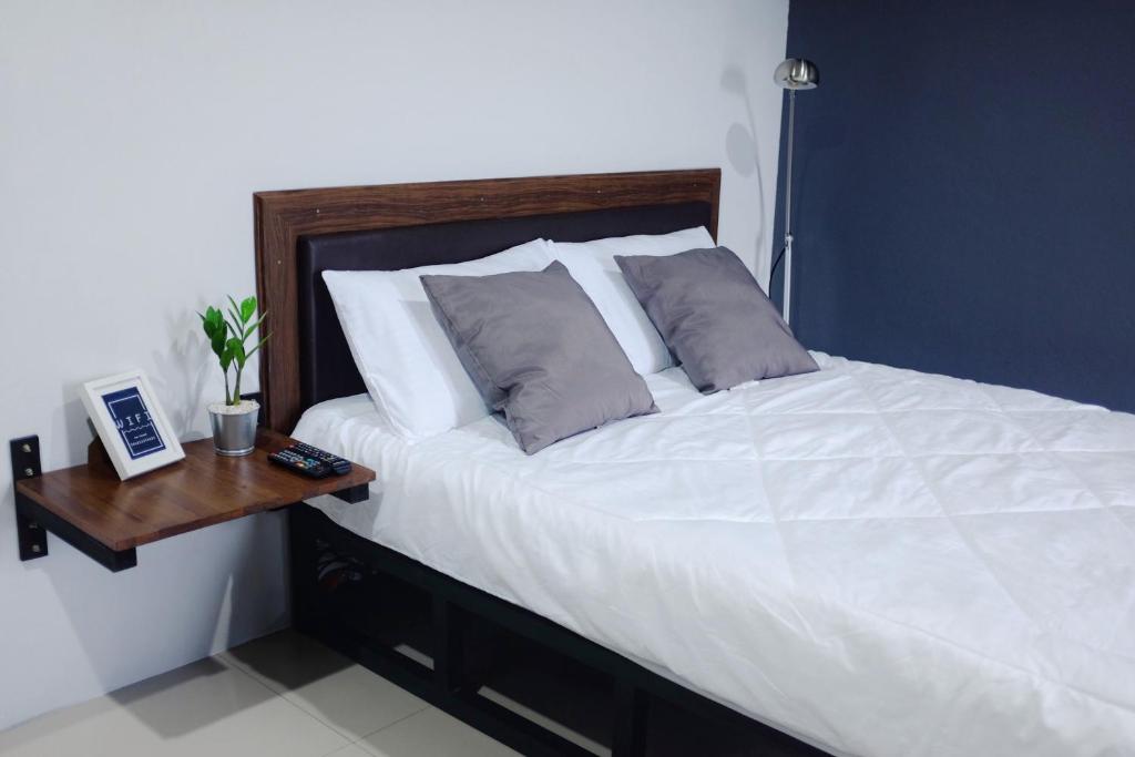 素叻The room Apartment的卧室配有一张白色的床和木桌