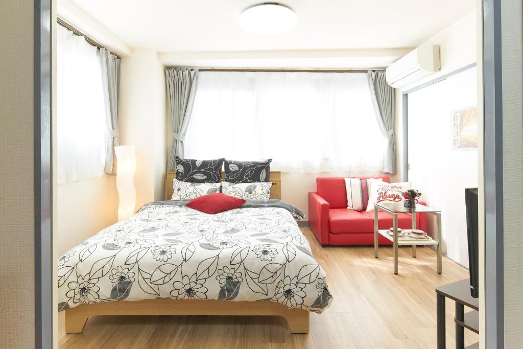 东京ESPERANZA103 広い綺麗快適高速WiFi的一间卧室配有一张床和一张红色的沙发