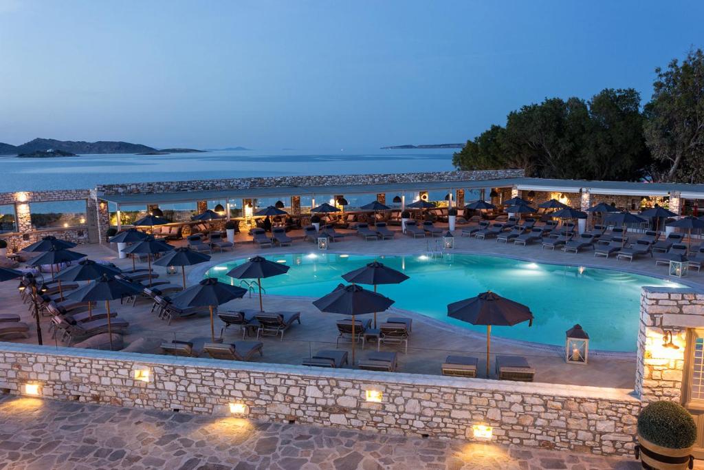 纳乌萨Saint Andrea Seaside Resort的一个带桌椅和遮阳伞的大型游泳池