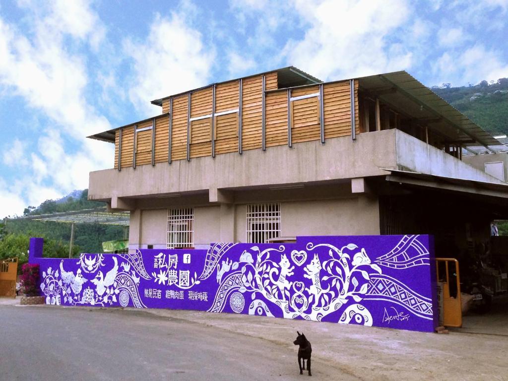 尖石乡水田私房农园的一座建筑,上面有紫色和白色的壁画