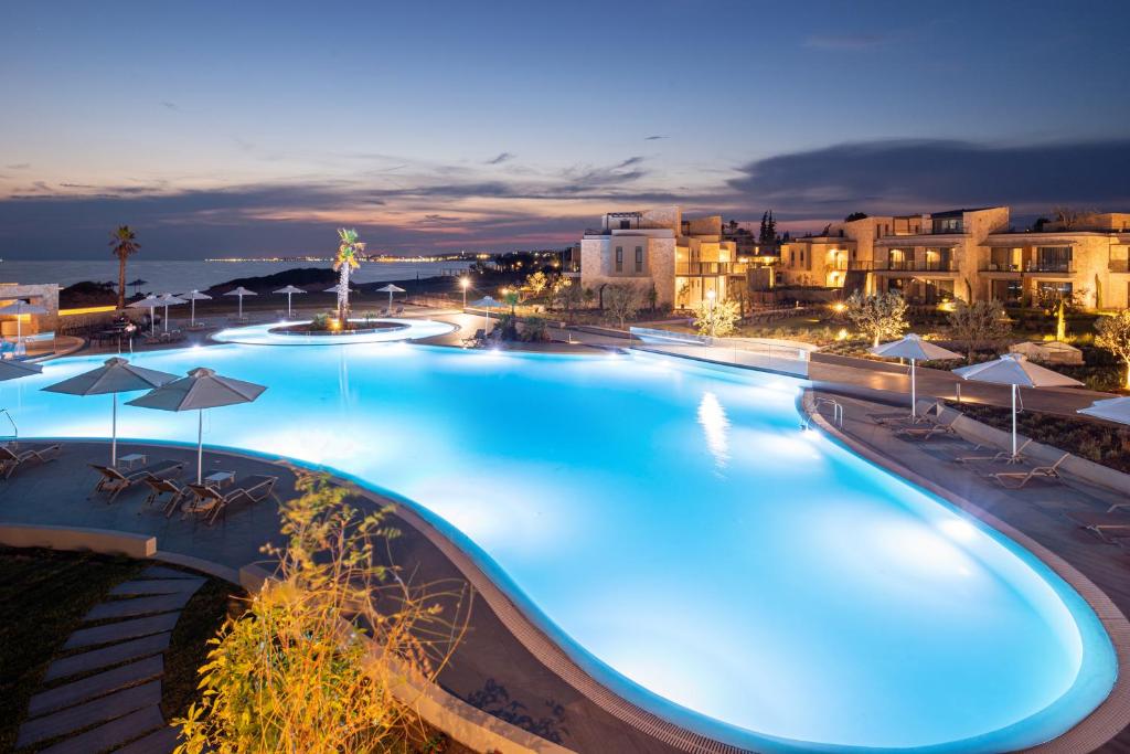 尼坡帝Portes Lithos Luxury Resort的夜间带蓝色灯光的大型游泳池