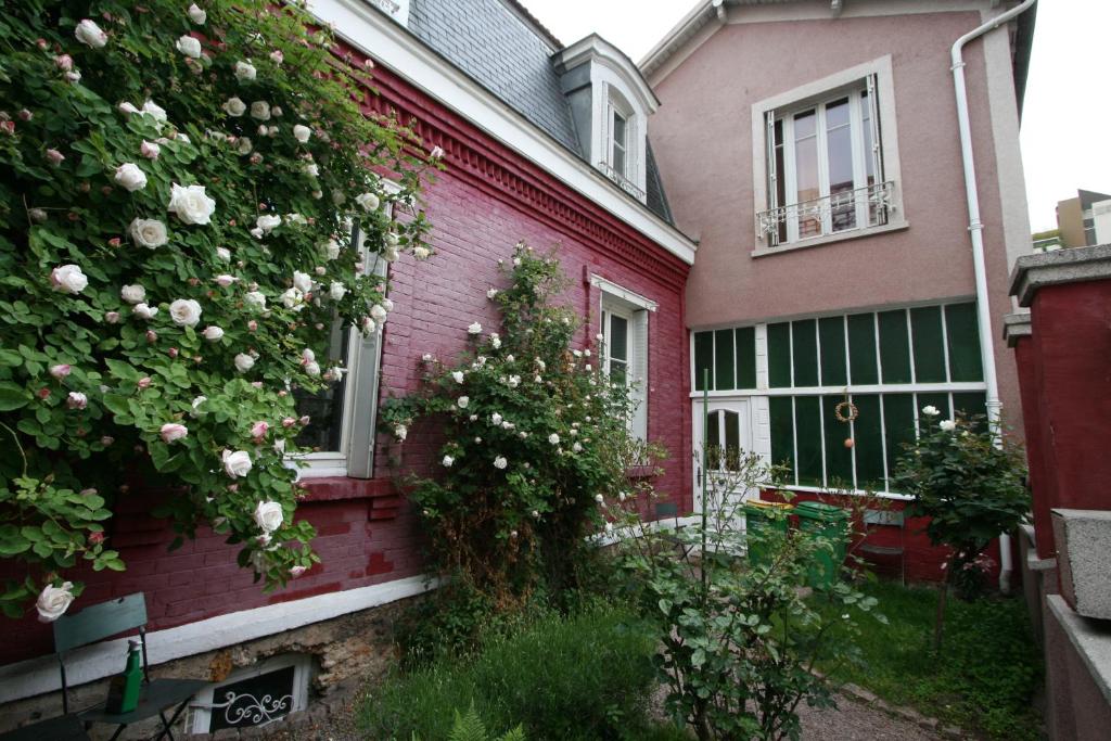 巴黎拉美苏鲁吉酒店的粉红色的房子,旁边是玫瑰