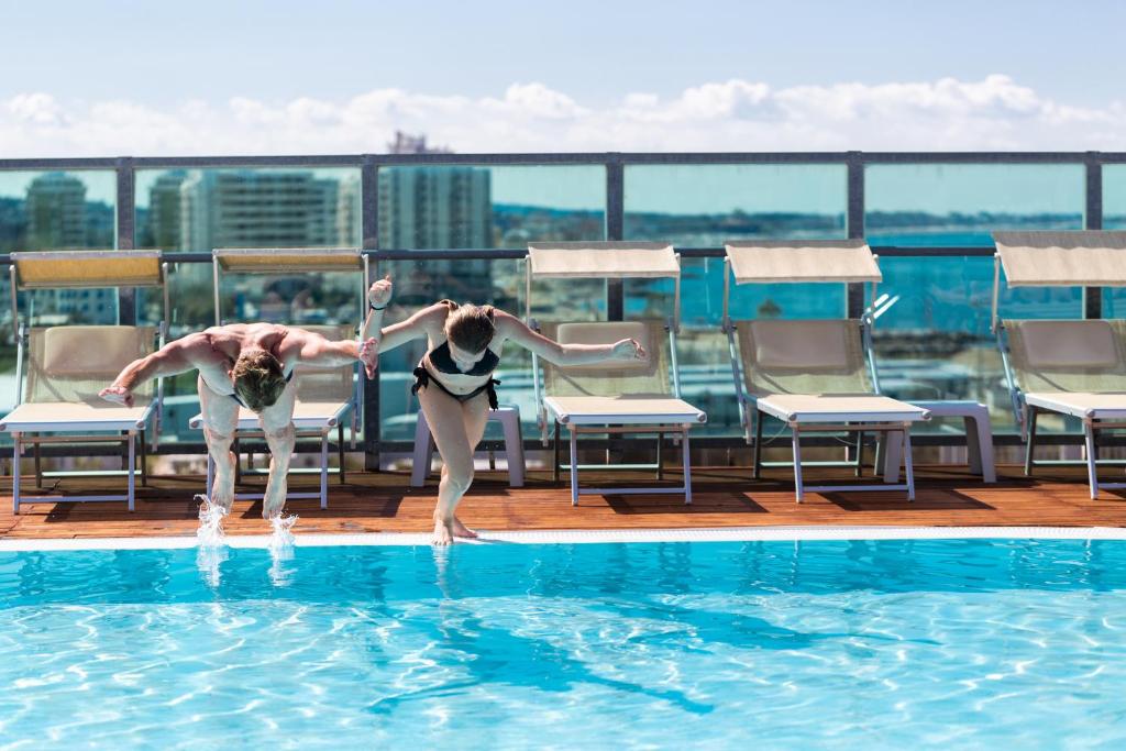 卡托利卡Hotel Universal的两人在屋顶游泳池玩耍