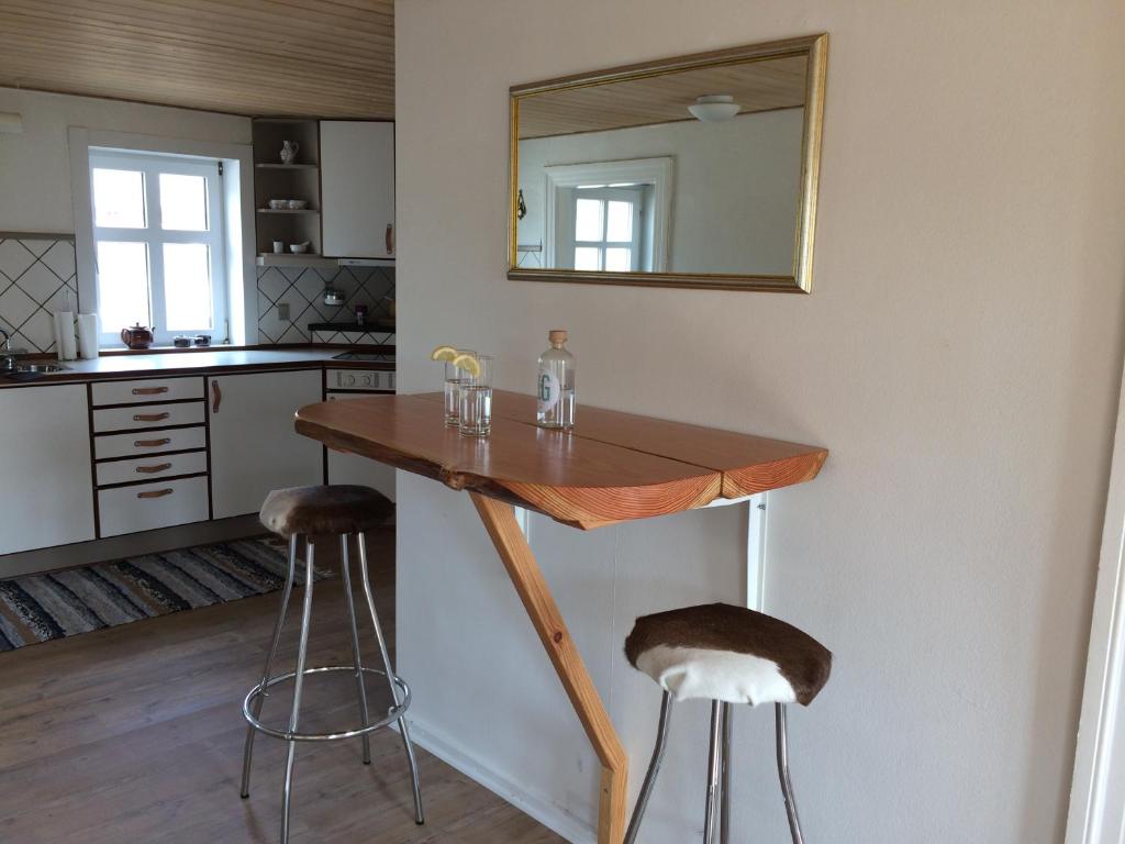 TverstedSejtræk Apartments的厨房配有木桌和2个吧台凳