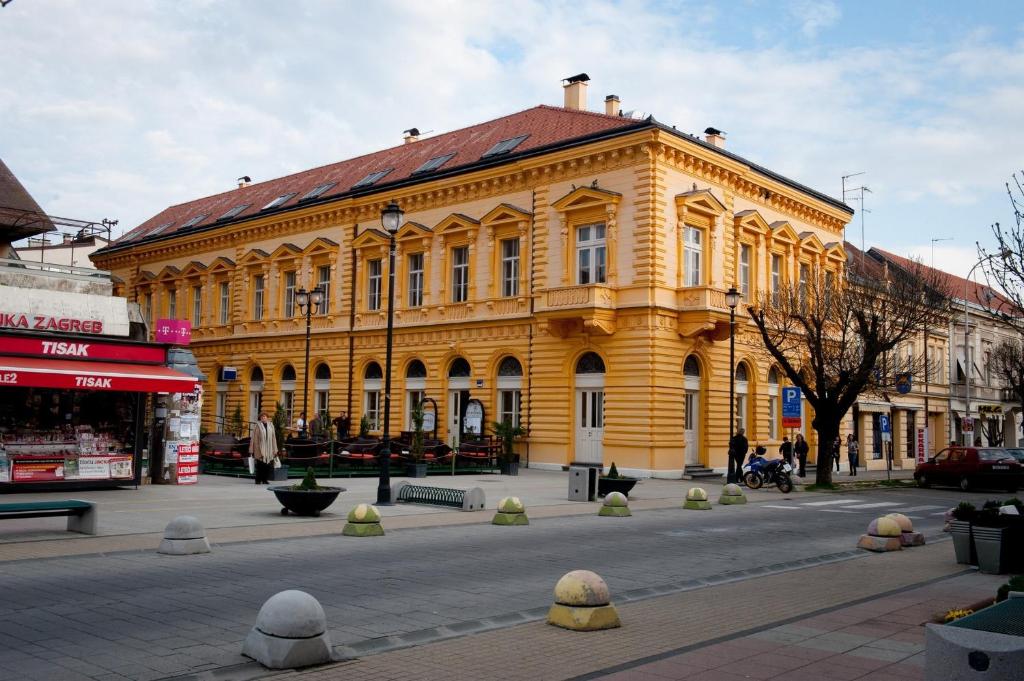 达鲁瓦尔Smještaj Slavonija的一条城市街道上的黄色大建筑