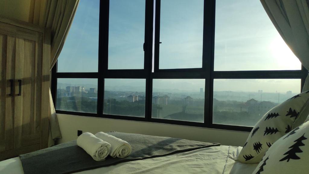 普特拉贾亚Conezion Luxury 3BR for 7pax @IOI Resort Putrajaya的卧室在窗前的床上配有2条毛巾