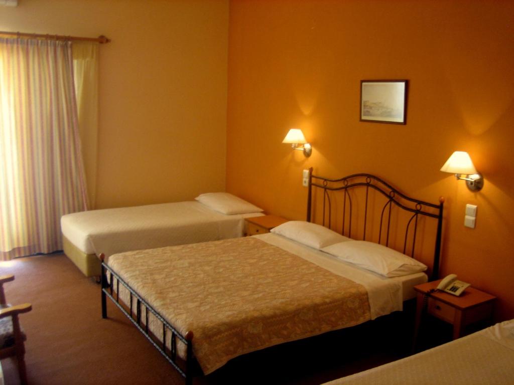 MykinesLa Petite Planete的酒店客房设有两张床和电话