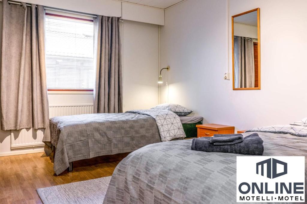 波尔沃Motelli Online Oy的酒店客房设有两张床和窗户。