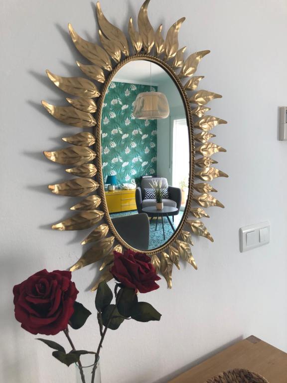 莫切El Balcón de Rosita的墙上的镜子,花瓶上放着玫瑰