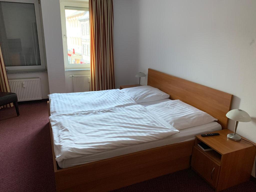 基尔恩Pension Hannes的一间卧室配有一张带白色床单的床和一扇窗户。