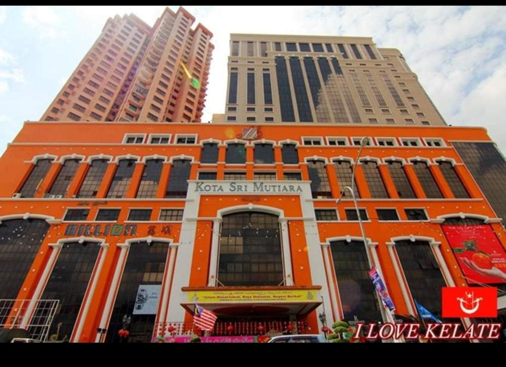 哥打巴鲁# Free Netflix CMK KONDOMINIUM KOTA SRI MUTIARA的一座橙色的建筑,有两座高大的建筑