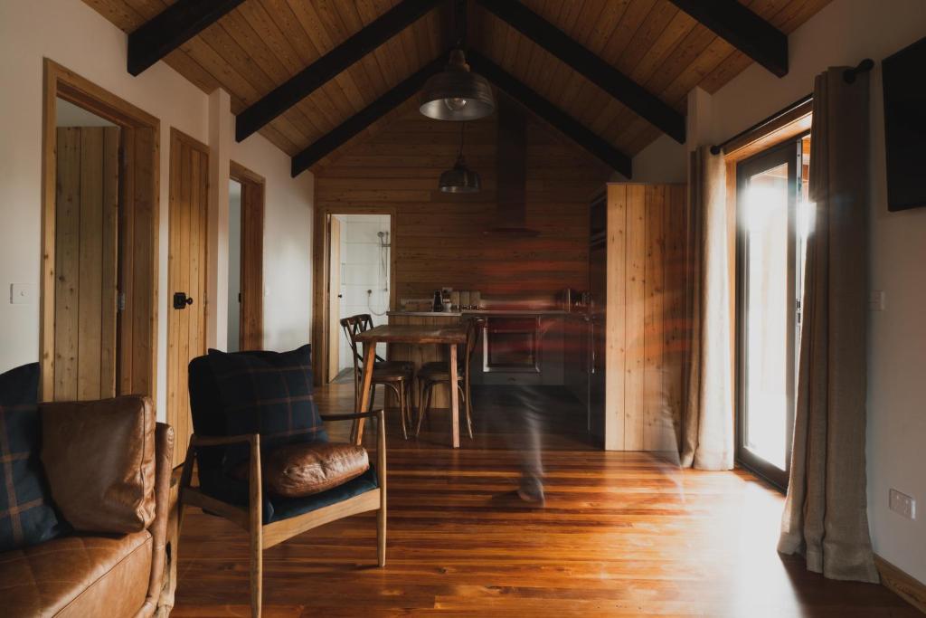 特卡波湖Alpine Lodges的客厅铺有木地板,配有桌椅。
