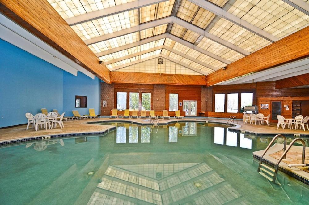 莱克哈莫尼波科诺酒店及会议中心 - 波科诺山脉的大楼内带桌椅的大型游泳池