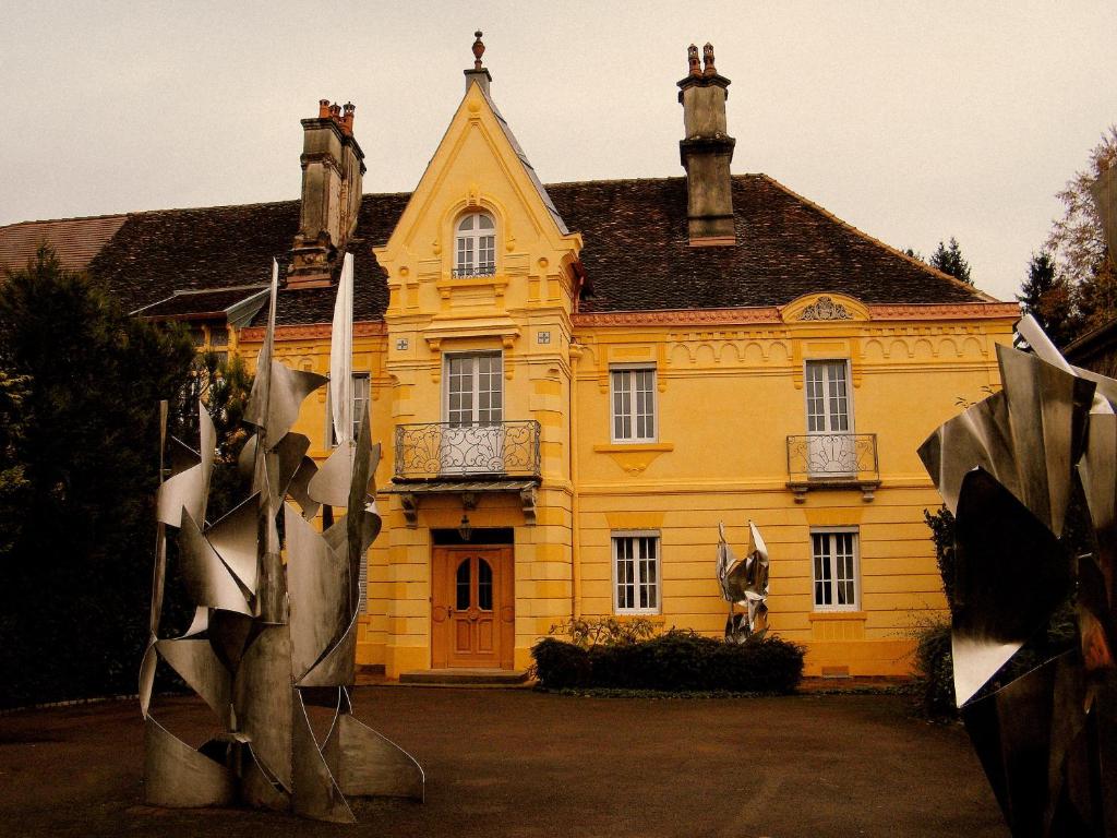 吕克瑟伊莱班嘉布遣别墅公寓的前面有雕像的黄色房子