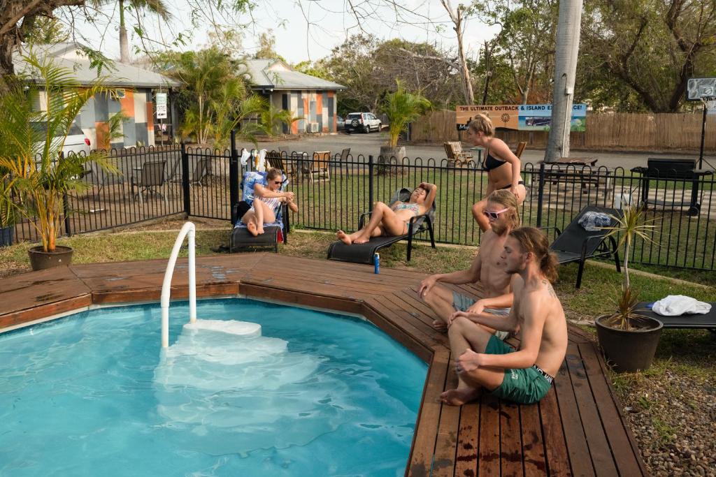 洛坎普顿Rockhampton Backpackers YHA的一群人坐在游泳池周围