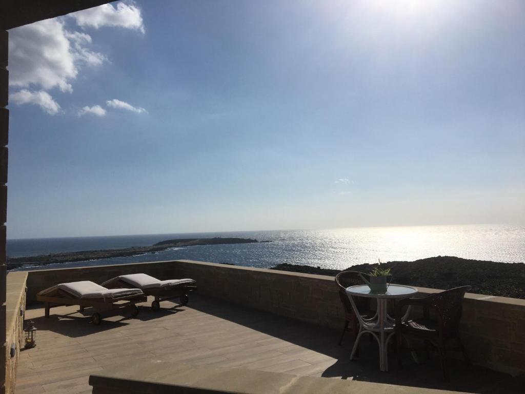 埃拉福尼西岛Elafonisi Villa above the Beach的一个带桌椅的海景阳台