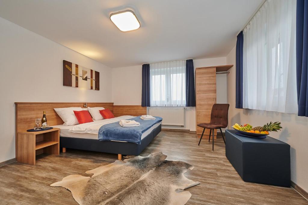 施特劳宾Sunny Hotel Straubing的酒店客房,配有一张床铺和一张桌子,还有一间客房