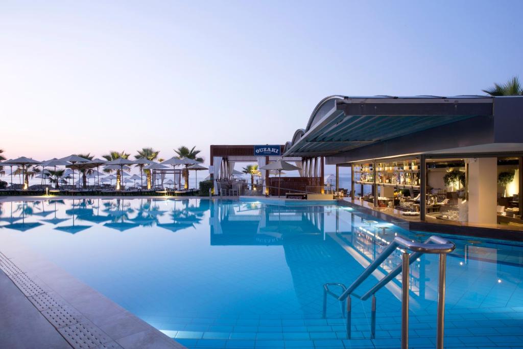 埃亚玛琳娜奈奇多塔拉萨海滩Spa度假酒店（仅限成人）的蓝色的水和遮阳伞的游泳池