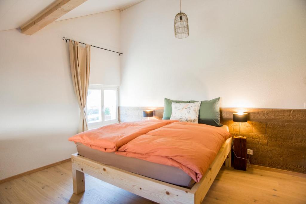 圣于尔萨讷BnB Logis des Saules的一间卧室配有一张带橙色棉被的床
