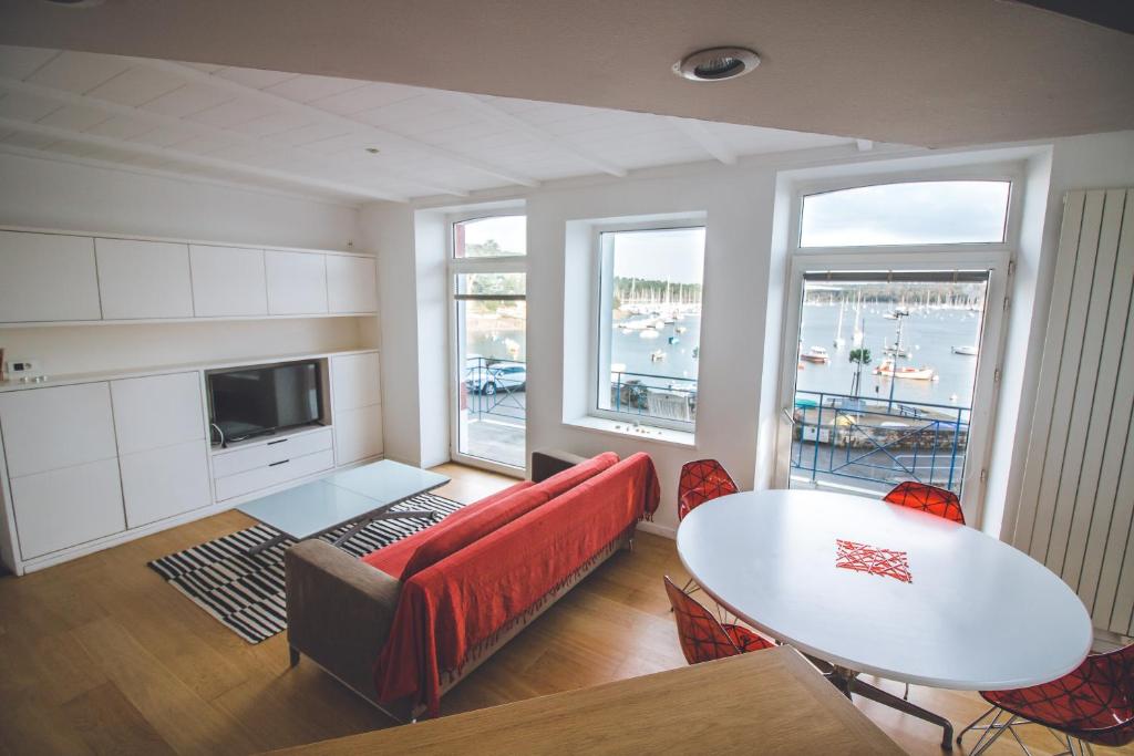 康布里特Appartement sainte marine vue mer的客厅配有红色的沙发和桌子