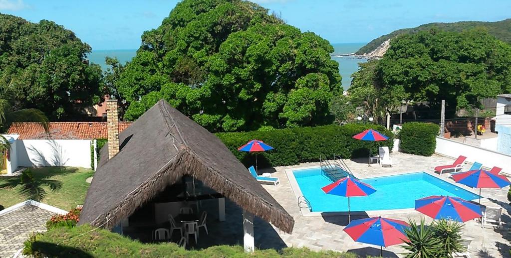 纳塔尔Yacht Village Natal Prime的享有带游泳池和遮阳伞的度假村景色