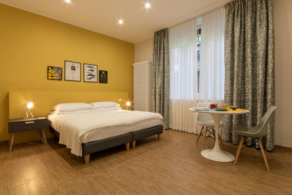 韦尔巴尼亚Aqualago casa vacanze apartment A的一间卧室配有一张床、一张桌子和一个窗户。