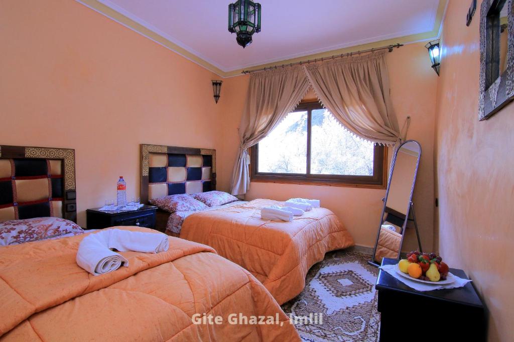 伊姆利尔Gite Ghazal - Atlas Mountains Hotel的一间卧室设有两张床和窗户。