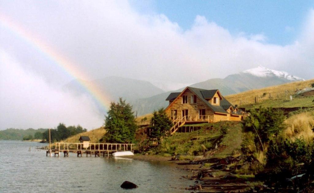 埃尔布兰科Lodge de Montaña Lago Monreal的湖上房子前面的彩虹