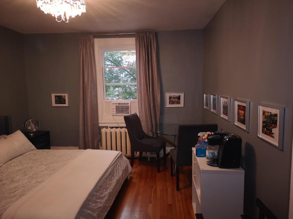 蒙特利尔Room with King Bed in Shared 3 Bedroom Downtown的一间卧室配有一张床、一张书桌和一个窗户。
