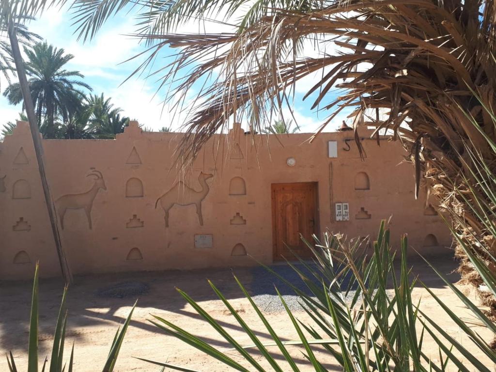 Aït BoukhaMaison etoile du desert的一座建筑,墙上有骆驼