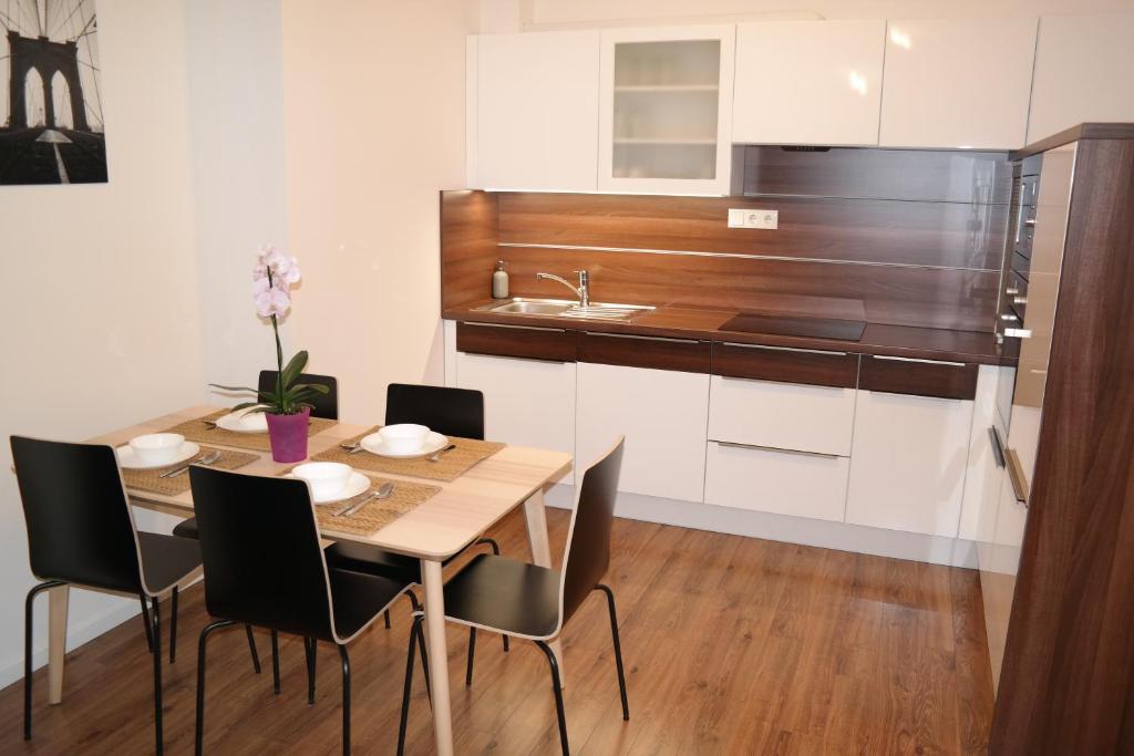 杰尔Riverside Apartman with Free Parking的厨房配有桌椅和水槽。