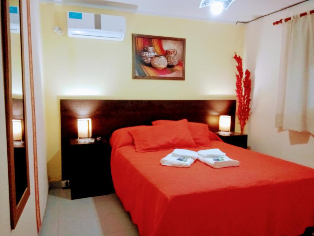 迈普Departamento Arenas的一间卧室配有红色的床和2条毛巾
