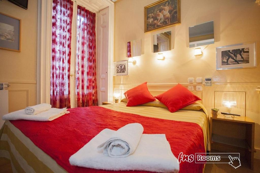 马德里拉丰塔纳旅馆的一间卧室配有红色的床和毛巾